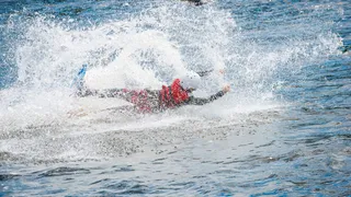 person slips on board and splashes in water