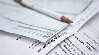 A close up of an earnings statement and payroll paperwork