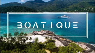 Boatique logo over photo of yacht in blue waters