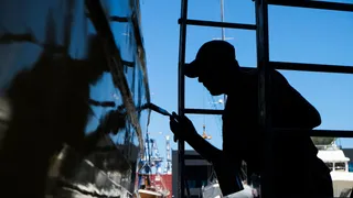 A worker removing tape from a paint job