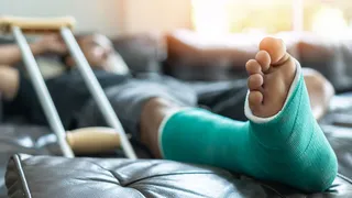 Person lying on coach with leg in cast